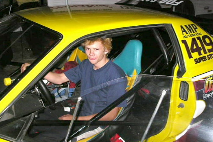 Logan West at the wheel of a racing car.