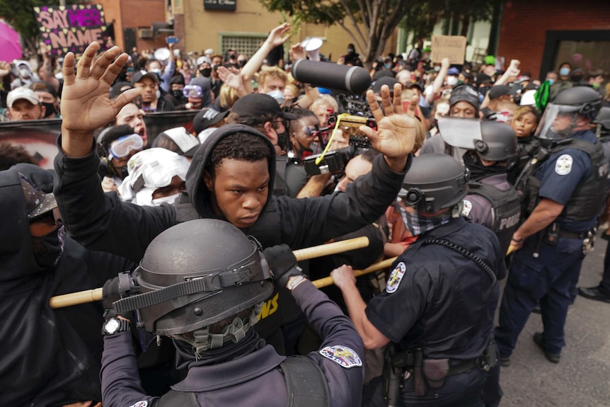 Police and protesters converge during a demonstration as police cordon off the area.