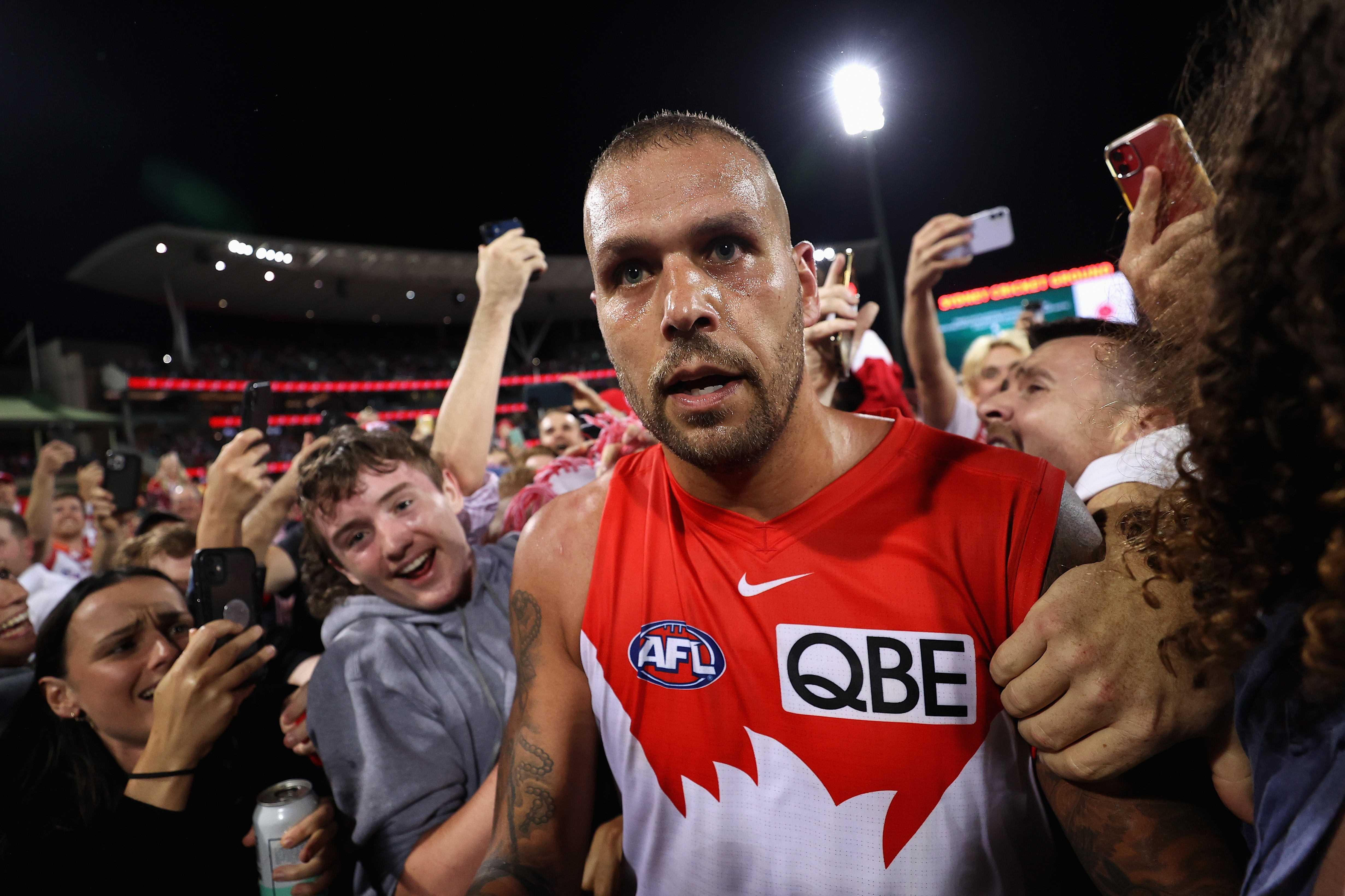 Lance Franklin looks serious as he moves while a massive crowd of fans get up close and personal