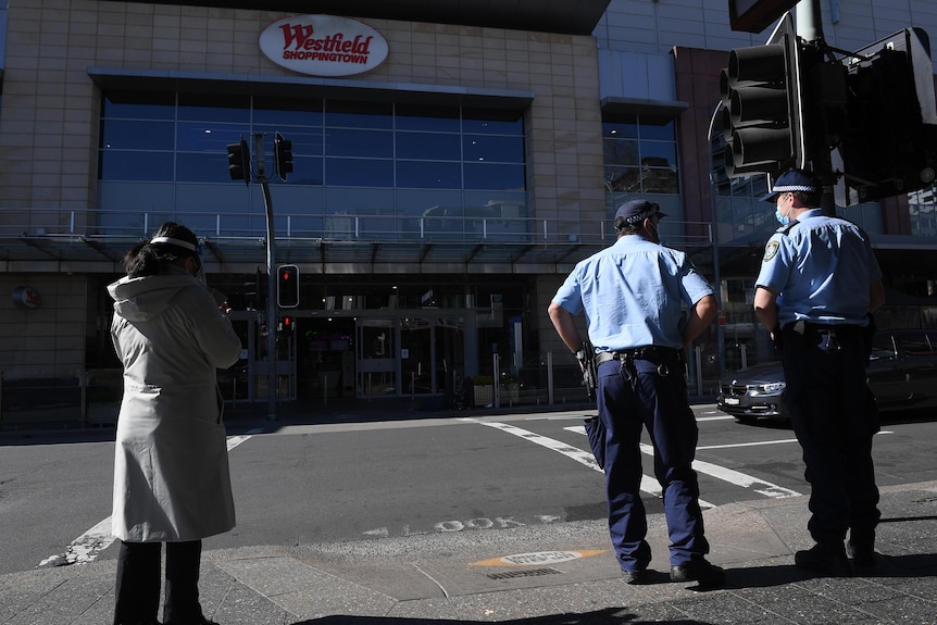 Two police officers stand on empty street