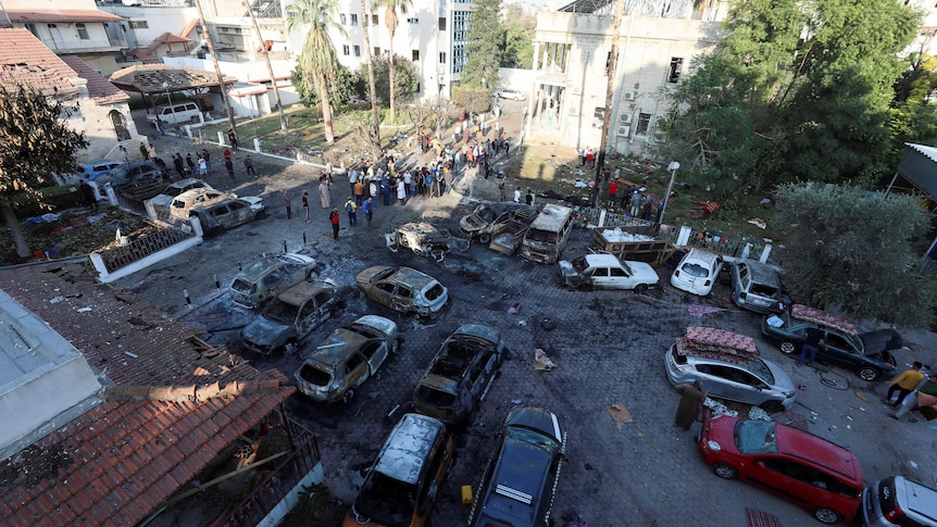A courtyard of a hospital showing burned out cars and fire damage.