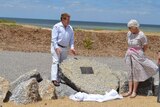 Yorke Peninsula Council Mayor Ray Agnew unveiling a plaque set on a rock near the beach where seven sperm whales died