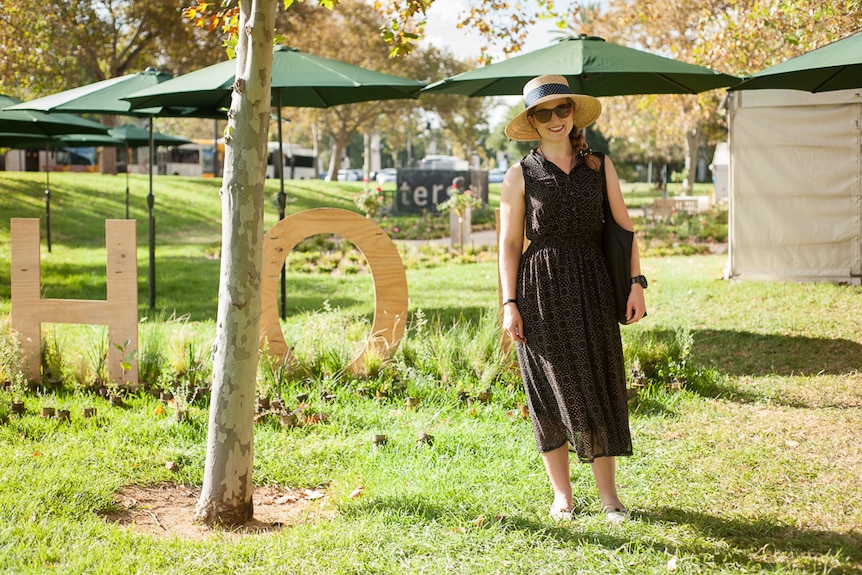 Brianna Rostiano wearing a large straw hat amidst the greenery of the Adelaide Writers' Festival