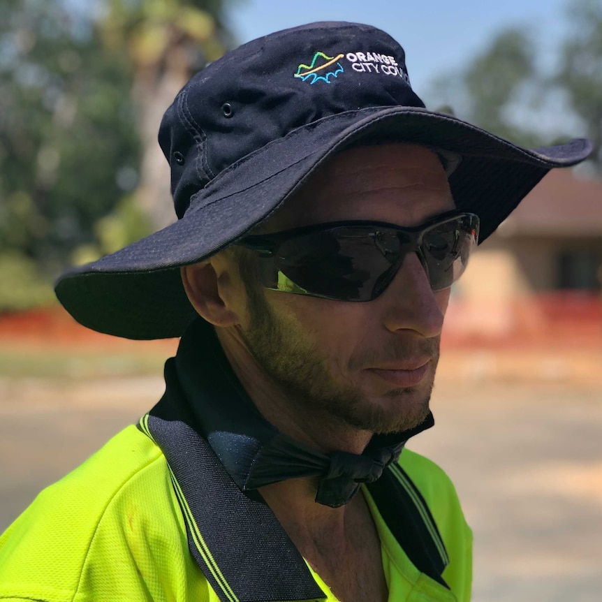 Roadworker Shane Wells wears a cool collar around his neck while working during a heatwave