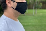 Profile of man wearing black mask