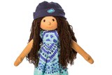 A doll with brown skin, long dark hair, a beanie and a light blue dress with an Indigenous design.