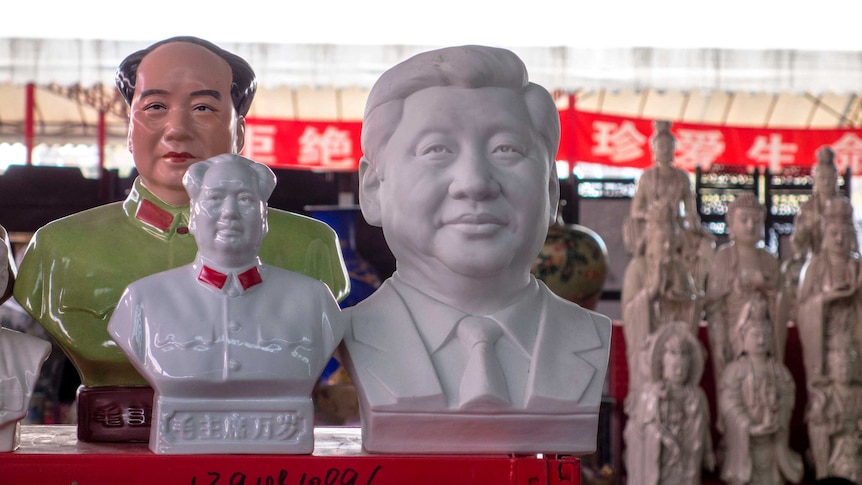 Porcelain statue of Mao Zedong and Xi Jinping on a stall.