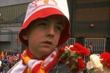A Liverpool supporter holds flowers