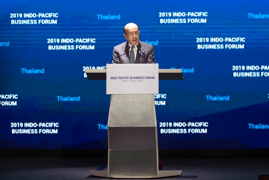 Wilbur Ross stands behind a metal lectern in front of a giant blue screen that reads '2019 Indo-Pacific Business Forum'