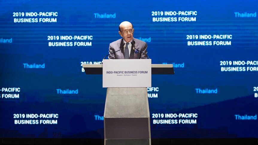 Wilbur Ross stands behind a metal lectern in front of a giant blue screen that reads '2019 Indo-Pacific Business Forum'