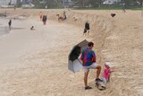 People look at scarping at Burleigh Heads beach on Queensland's Gold Coast.