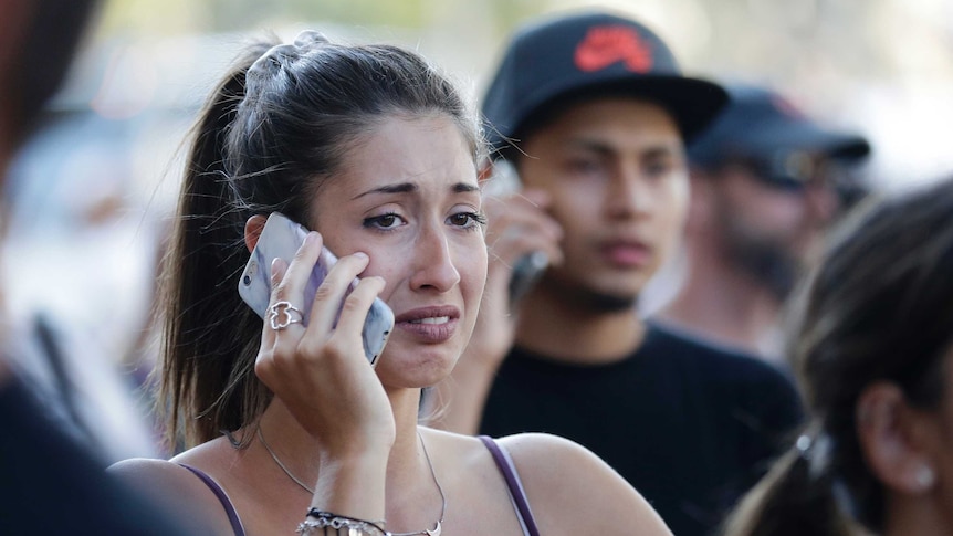 A distraught woman talks on her phone.