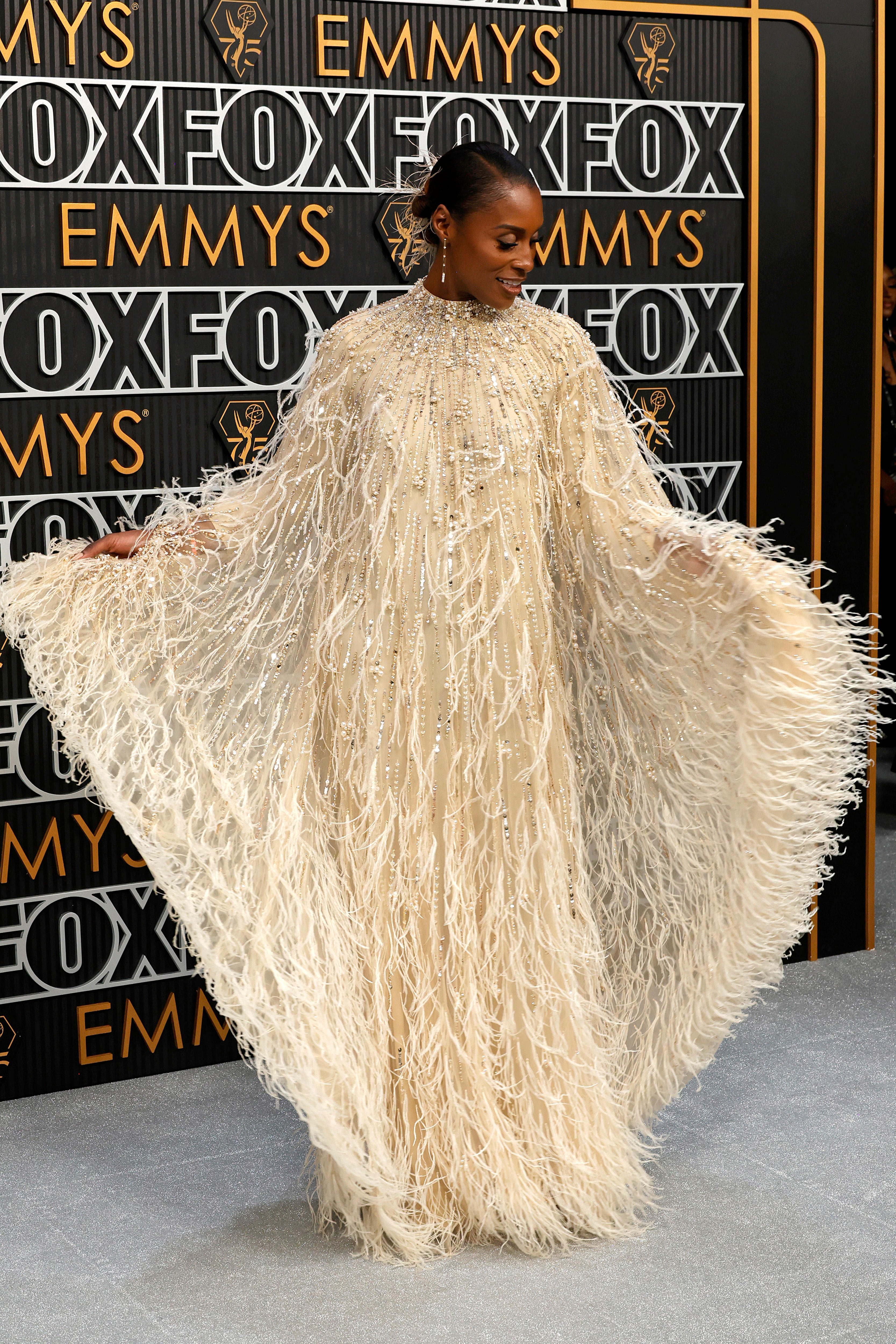 A woman in a white feathered dress on a red carpet.