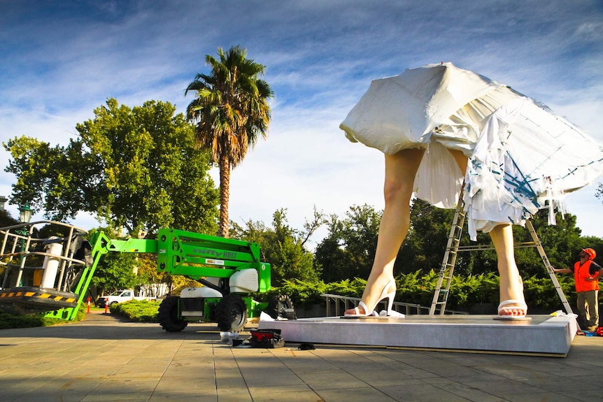 Giant pair of legs on plinth in garden