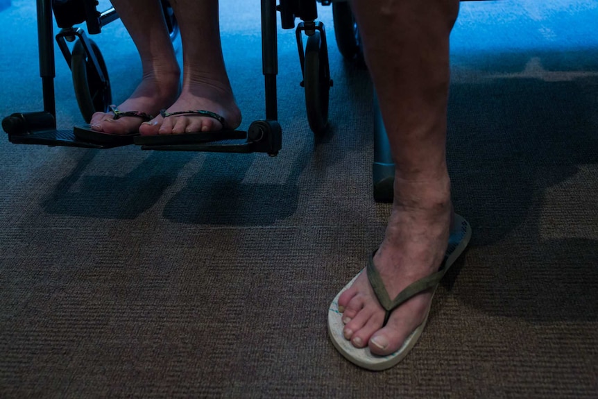 Sue and Peter's feet in thongs while they wait for a radiotherapy appointment.