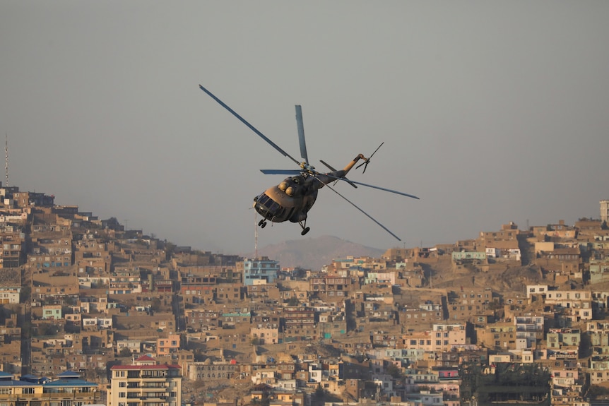 A military helicopter flies over Kabul during a Taliban military parade
