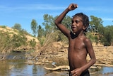 A boy stands in a river