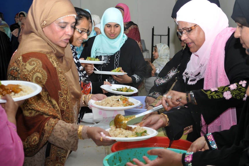 Women serve dinner at the Darra Mosque after breaking the fast for Ramadan on August 5, 2011.