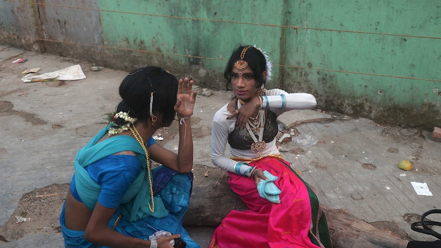 Indian transgender dancers put on makeup before a performance for a function in Kolkata
