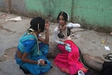 Indian transgender dancers put on makeup before a performance for a function in Kolkata