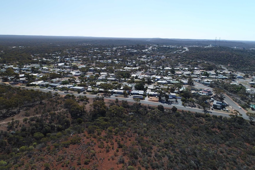 An aerial view of a township amid an outback bush landscape.