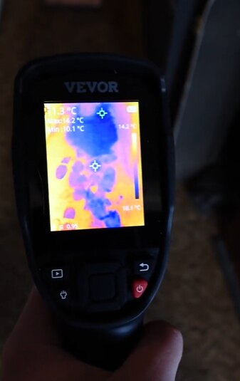 A photo showing thermal imagery of foot marks and black puddles in a rental property.