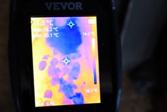 A photo showing thermal imagery of foot marks and black puddles in a rental property.