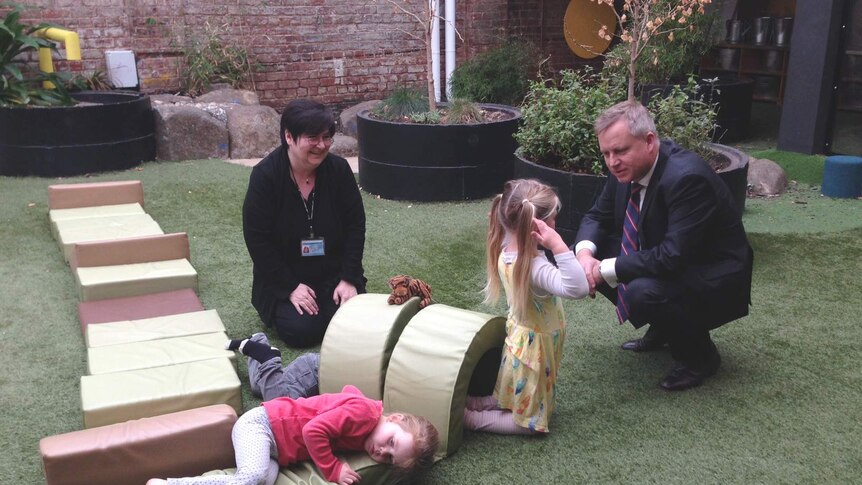 Tasmanian Education Minister Jeremy Rockliff talks to a young child.