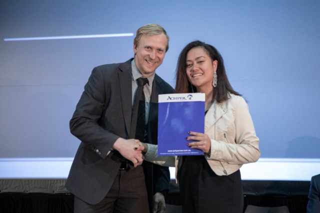 man and young woman shaking hands while she holds up a certificate