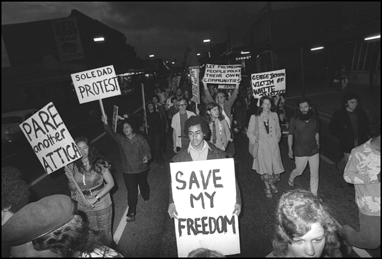 Black and white image shows a young Dr Anae with a sign. 