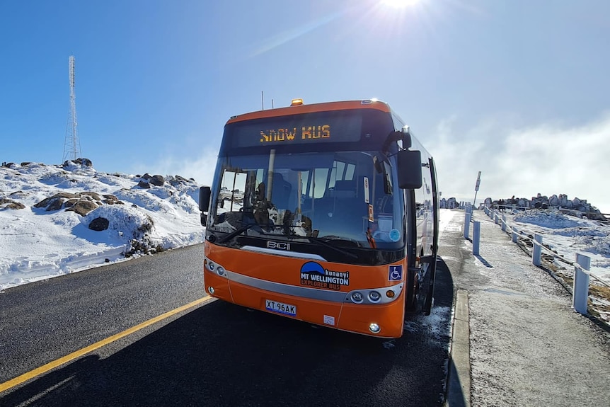 Bus on snow covered mountain summit.