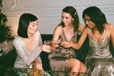 Three women in dresses drinking champagne