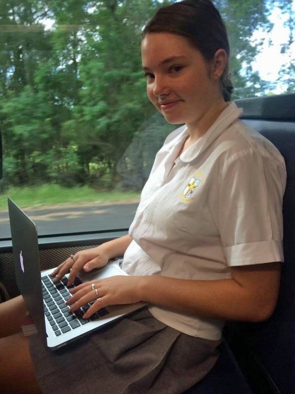 A school student on a laptop on the bus