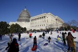 People sled and play in the snow on the hill below the U.S. Capitol in Washington.
