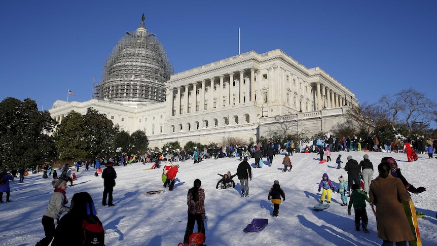 People sled and play in the snow on the hill below the U.S. Capitol in Washington.