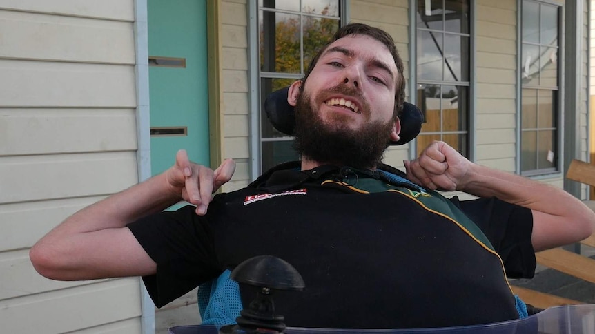 Mr Turner-Thomas smiles for the camera outside his almost-built home.