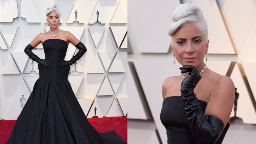 Lady Gaga pouts in a black gown and long, black gloves on the Oscars red carpet.
