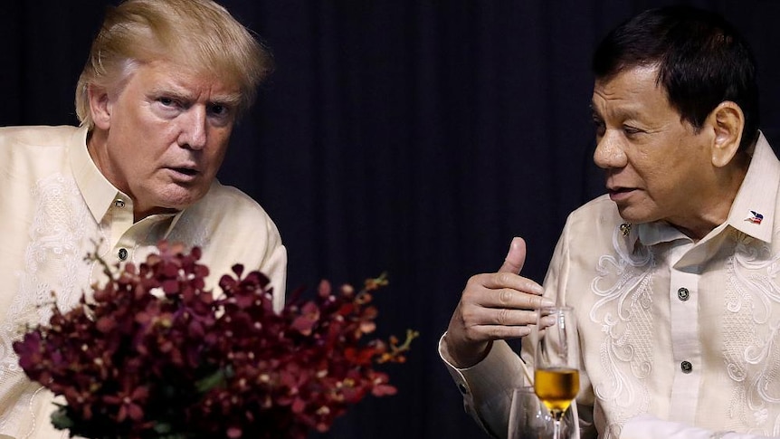 Donald Trump leans over to Philippines President Rodrigo Duterte at an ASEAN summit gala, both in cream barongs