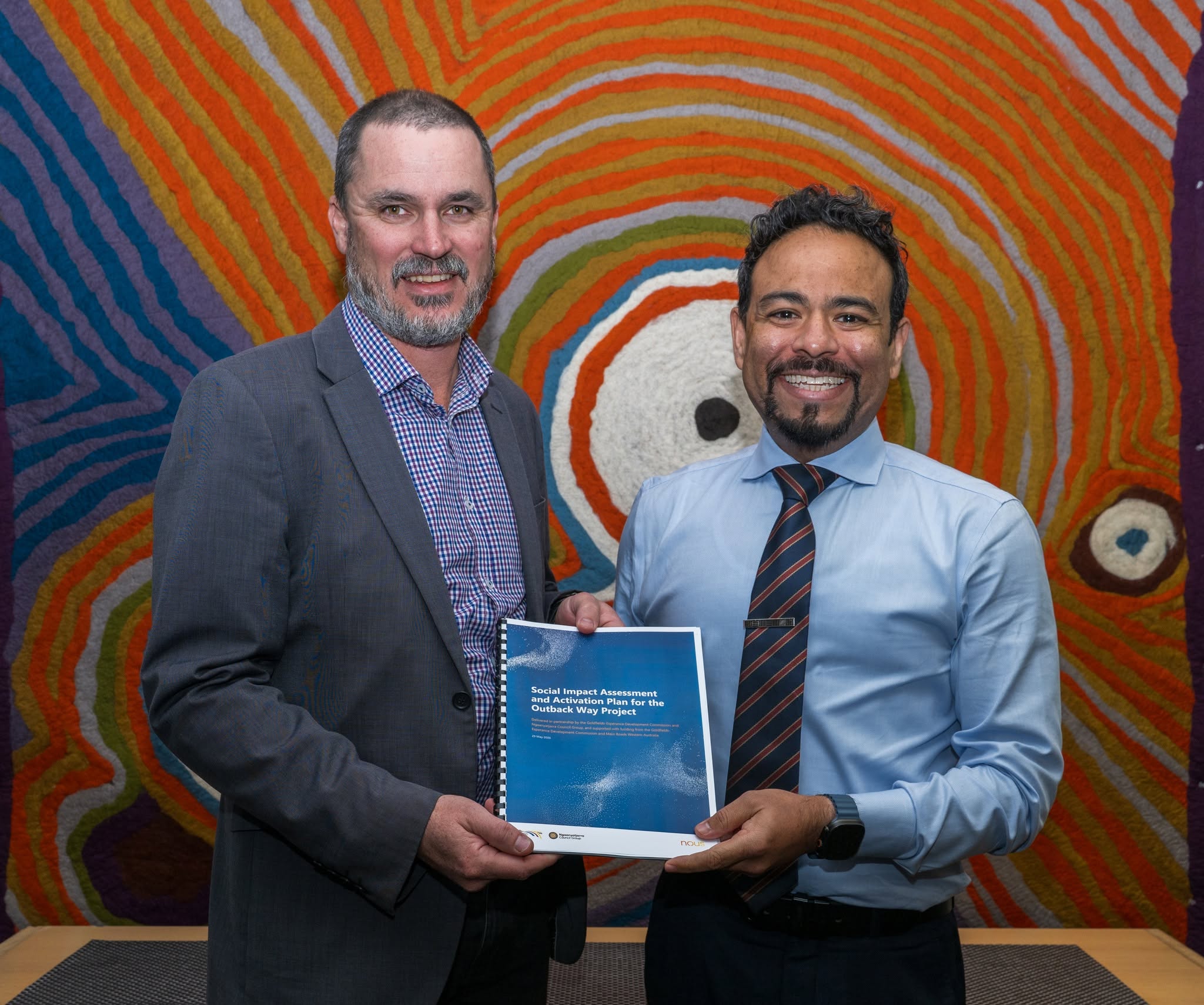 Two men holding a report.