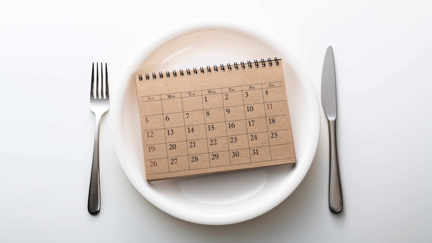 a calendar on a plate with a knife and fork on either side
