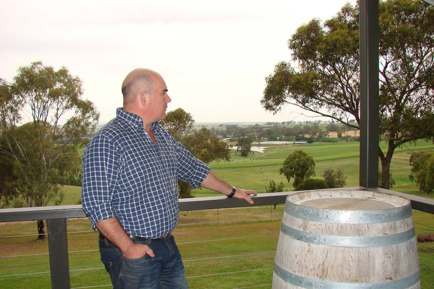 Jason Brown stands on his balcony overlooking his grape vines and dams at Moppity Vineyards near Young New South Wales