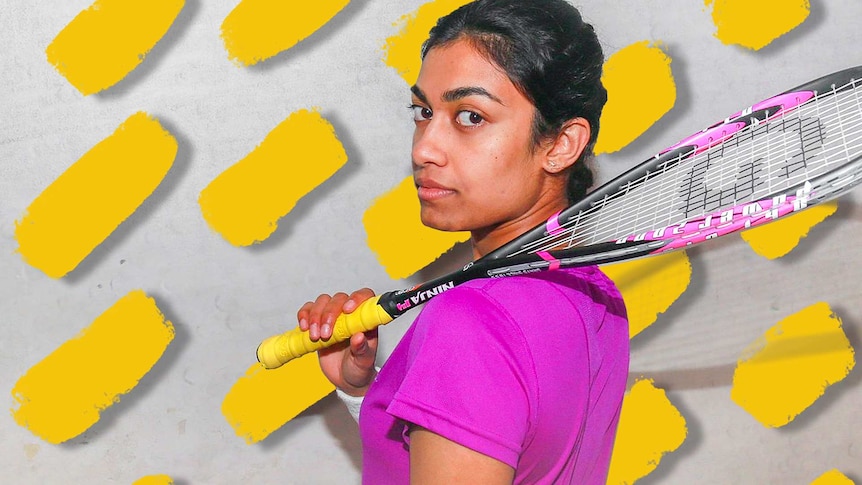 Female stands in front of wall with squash racquet over her shoulder.