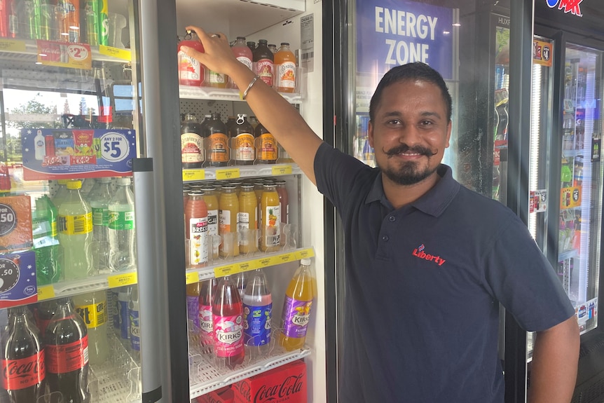 Man standing in front of drinks fridge