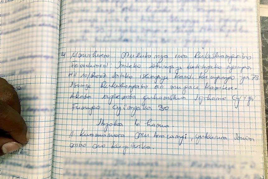 A notebook with handwritten writing not in English with the name Rukeshangabo visible