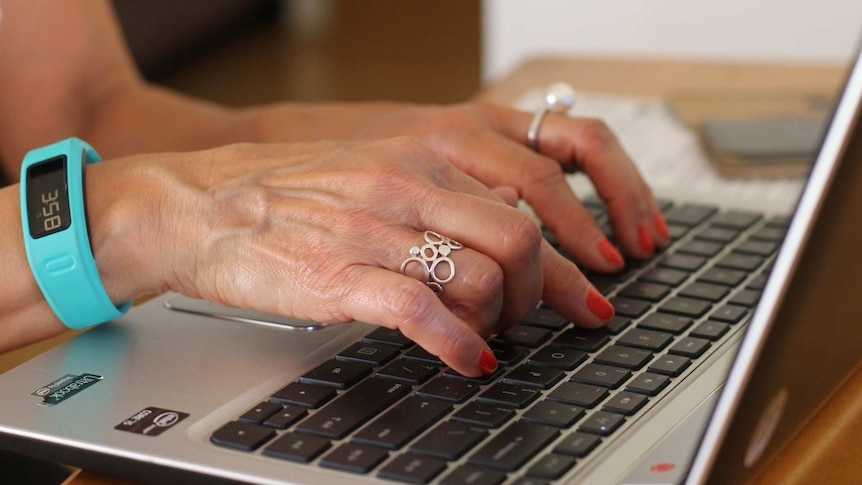 women's hands typing on a lap top