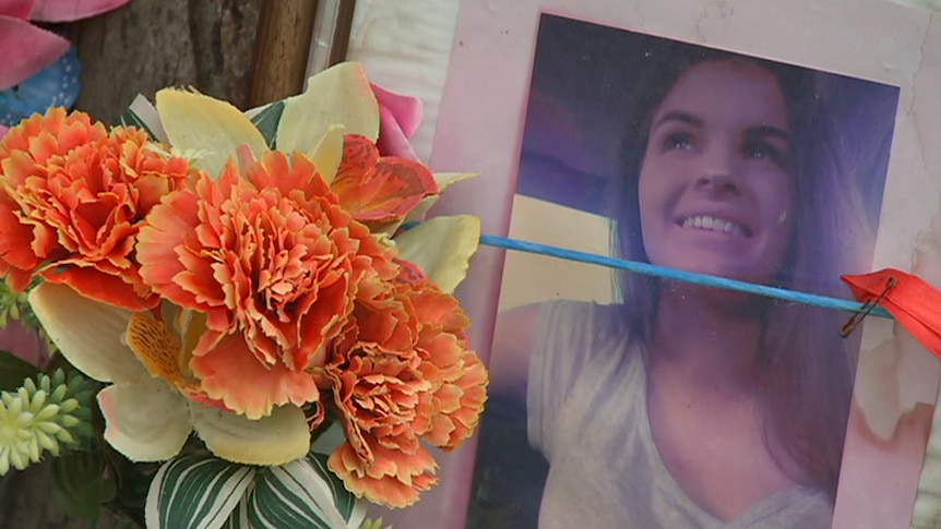 Orange flowers next to a printed photo of a young woman.