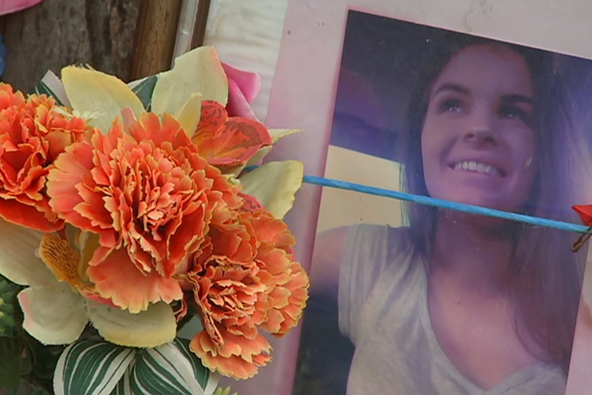 Orange flowers next to a printed photo of a young woman.