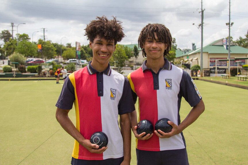 Two students holding bowling balls.