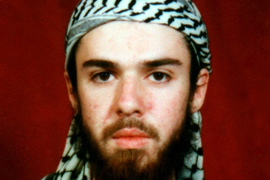 A portrait photo of a white US man wearing a head scarf