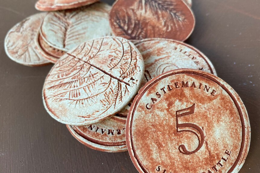 pièces de monnaie en argile avec 1 et 5 dessus et une impression d'acacia au dos.